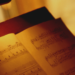 Ein Notenpult mit einem aufgeschlagenen Musikstück, warm beleuchtet von einer Lampe