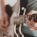 Eine Person spielt E-Gitarre.