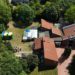 Luftbild. Die Elia-Kirche und ihr Garten, in welchem Pavillons und eine bunte Hüpfburg stehen.