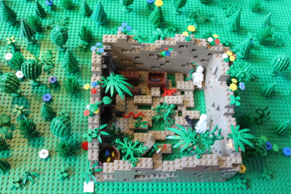 Eine überwucherte Ruine aus grauen Legosteinen. Darin Skorpione und Skelette.