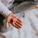 Eine Kinderhand hält ein kleines, rosafarbenes Herz.