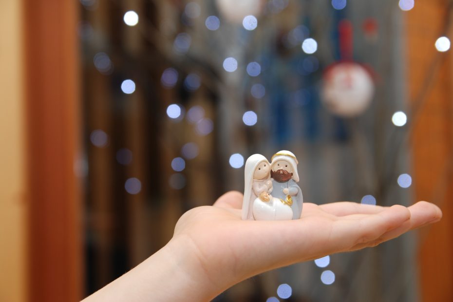 Maria, Josef und Jesus als kleine Figuren. Sie stehen auf einer Hand.