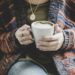 Eine Person hält eine Kaffeetasse
